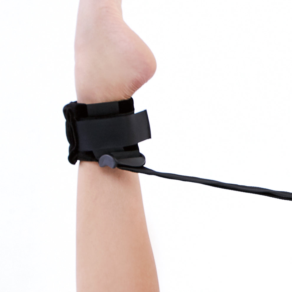 Black ankle brace on a person's foot with a white background