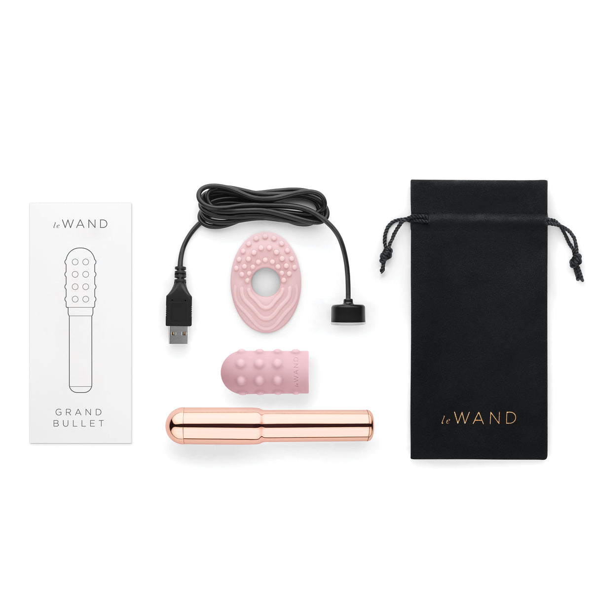 "Flat lay" view showing the Grand Bullet, textured silicone sleeve, textured ring, charging cable, pouch, and manual arranged neatly on a white background.